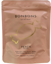 A stand-up pouch  144g of Bonbons by Oh My Gumi peach hard candy. The packaging is a matte dusty peach-pink color with a metallic gold outline of a candy and black text.