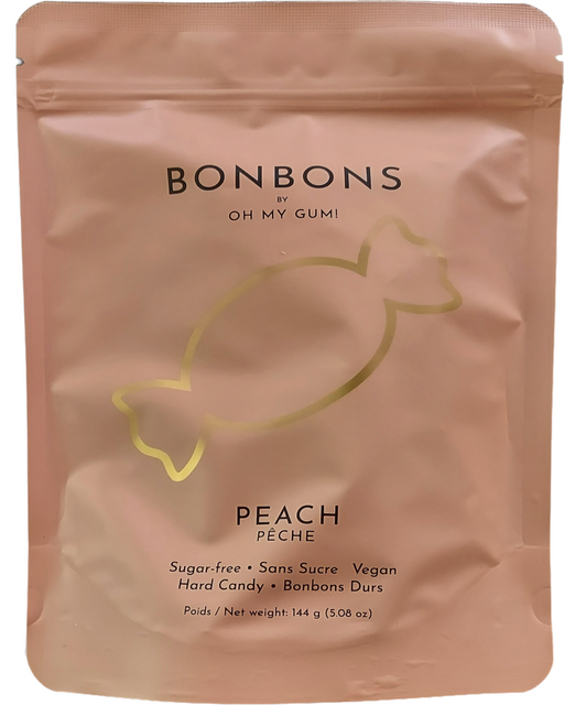 A stand-up pouch  144g of Bonbons by Oh My Gumi peach hard candy. The packaging is a matte dusty peach-pink color with a metallic gold outline of a candy and black text.